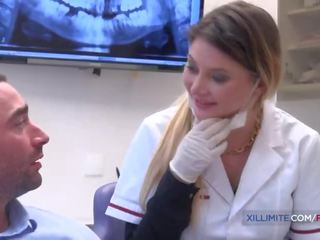 Blond dentist eikels haar patiënt